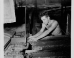 GI of the 797th Engineer Forestry Company in Burma, adjusting saw blade guide in mill.  During WWII.