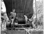 GI pulls logs with donkey engine in Burma.  797th Engineer Forestry Company in Burma.  During WWII.