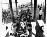 Engineers of the 797th Engineer Forestry Company eating fancy meal in Burma, possibly in the stilt space under a private home.  During WWII.