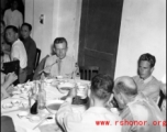 16th Combat Camera Unit members enjoy a banquet in China during WWII. Hal Geer holds up a jiaozi (饺子) in his chopsticks as he looks at the camera.