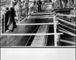 Pouring a concrete foundation as part of American air base construction in China during WWII.  Chinese laborers pouring concrete into forms.