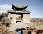 A decorative gate, strangely by itself, in the countryside somewhere in Yunnan province, China. During WWII.