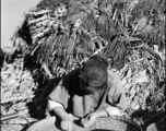 Local people in China, probably in Yunnan province: A woman picking through grain by hand.  From the collection of Wozniak, combat photographer for the 491st Bomb Squadron, in the CBI.