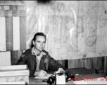 An American soldier with "Flanagan" (花纳根）on his jacket in the CBI. Notice the "491st Bomb Squadron daily status" on the wall behind him.  This is a photo of Captain James Flanagan who was the operations officer of the 491st Bomb Squadron. This photo was taken probably at Yangkai Airbase in late 1944. Please see: http://www.usaaf-in-cbi.com/ for additional information. (Thanks to sds)  From the collection of Wozniak, combat photographer for the 491st Bomb Squadron, in the CBI.