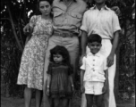 A GI poses with a young family. People in the CBI.