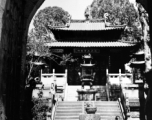 The central courtyard of local Buddhist temple in  China, probably in Yunnan province, with large bronze incense burner. During WWII.