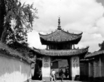 Local people and a whitewashed gate in Luliang, Yunnan province, China. During WWII.