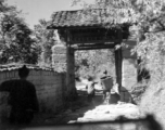 Villagers going through a narrow village gate in Yunnan province, China.