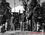 Local men stand on a small bridge in front of walled compound in Yunnan province, China. During WWII.