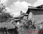 A village in Yunnan province, China, with adobe houses, and cactus growing on fences.