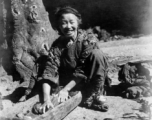 Woman washes clothing in wood trough. In Yunnan, China, during WWII.