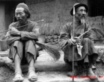 Men smoking pipes in a village in Yunnan, China, during WWII.