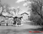 Local people and American visitor in a pavilion over a small pond near Yangkai,  Yunnan province, China. During WWII.