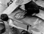 Local people washing vegetables  in Liuzhou city, Guangxi province, China, during WWII.