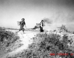 Fleeing women look back over their shoulders at a Japanese air raid on Kunming city in Yunnan province, China, during WWII.