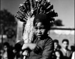 During WWII, a child sells candied fruit on the street, probably in Yunnan.  Local people in China, including a young candied fruit seller selling candied haws fruit on bamboo skewers.