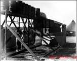 GIs shower outside under barrels, in the CBI during WWII.