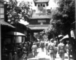 Drum or bell tower at the center of Kiunglai, with busy market street nearby, a shopping spot for GIs. During WWII.  Photo from C. W. Miller.