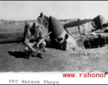 GI kneels before destroyed P-40 fighter in the CBI.  Photo from PFC Watson.