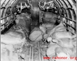 Bags are piled in cargo plane ready for aerial drop to Allied troops. Some will be dropped with parachutes to slow the drop (those in the distance in the image), and some will be dropped directly. In the CBI.