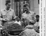 Bob Lichty (left) and John Darnell, both "sporting Indian caps," check out a nut vendor's stock in Bombay, India, during WWII.  Photo from Bob Lichty.