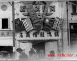 Victory "V" over shoe store in China at the end of the war, with the four flags of the Allies.