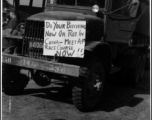 American truck with a sign advertising meeting at race course in the CBI during WWII.