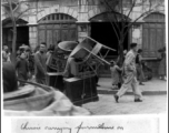 Chinese man carrying furniture in street of Kunming. March 1945.