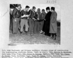 U. S. Army Engineers and Chinese engineers discuss plans of construction for Laohuangping Airfield, Guizhou, China.  Pfc. Melvin G. Watchorn, Pfc. Peter G. Bergum, Lt. James E. Beard, Capt. James F. Sabel, Parker Kwan, Siang Ting Chang, and James Sun.  Image courtesy of Tony Strotman.