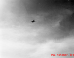 A B-25 Mitchell bomber high in flight in the CBI, in the area of southern China, Indochina, or Burma, during WWII.