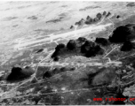 Runways among Karst peaks at the American base at Yangtong, Guilin, Guangxi province, China, during the Japanese occupation in late fall of 1944 until July 1945.  Bomb pits are visible in the runway in the foreground, which was blown up during the American evacuation to deny use to the incoming Japanese.