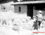 A farmer tends bundles of rice straw in SW China during WWII.