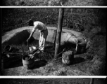 Farmer processing fertilizer (night soil) for the gardens. In Yunnan, China, during WWII.