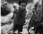 A child bearing a baby on her (most likely) back, during WWII, in Yunnan, China.