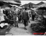 GI walking through market street at village near the American air base in WWII in Luliang, Yunnan province, China.