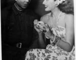 Celebrities visit and perform at Yangkai, Yunnan province, during WWII: Jinx Falkenburg poses with a Chinese soldier while she autographs a tennis ball.