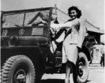 Paulette Goddard hanging onto a Y-force jeep, during WWII.