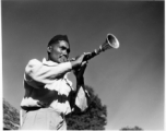 Man blowing horn.  Scenes in India witnessed by American GIs during WWII. For many Americans of that era, with their limited experience traveling, the everyday sights and sounds overseas were new, intriguing, and photo worthy.