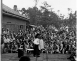 Celebrities (including here apparently Ruth Dennis) perform on an outdoor stage set up at the "Last Resort" at Yangkai, Yunnan province, during WWII. Notice both Americans and Chinese in the audience for this USO event.